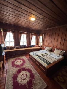 een slaapkamer met een bed en een bank in een kamer bij Къща за гости Никула Чорбаджи in Zheravna