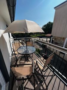 een tafel en stoelen met een parasol op een balkon bij Apartment Stinjan in Pula