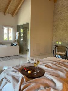 a room with a bed with two glasses of wine at Villa Tité in Oviedo