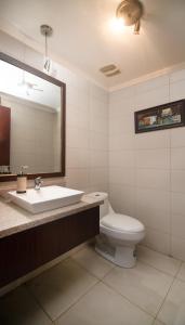 y baño con lavabo, aseo y espejo. en Departamento Riverfront 2, Puerto Santa Ana, Guayaquil, en Guayaquil