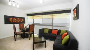a living room with a black couch and a table at Departamento Riverfront 2, Puerto Santa Ana, Guayaquil in Guayaquil