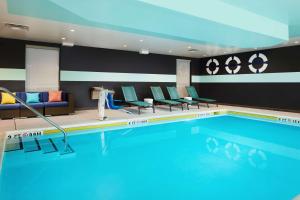 a swimming pool in a hotel with chairs and a couch at Tru By Hilton Charleston Airport, Sc in Charleston