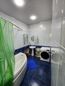 a bathroom with a tub and a toilet and a sink at Апартаменты in Tashkent
