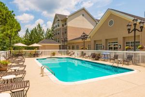 a swimming pool with chairs and a building at Homewood Suites by Hilton Birmingham South Inverness in Hoover