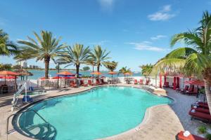 uma piscina com palmeiras e o oceano em Hampton Inn and Suites Clearwater Beach em Clearwater Beach
