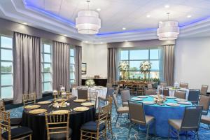 a conference room with tables and chairs and windows at Hampton Inn and Suites Clearwater Beach in Clearwater Beach