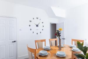 a dining room with a table and a clock on the wall at Brown Ball in Barrow in Furness
