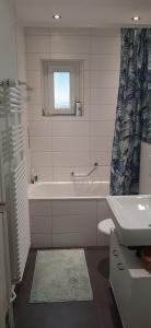 ein Badezimmer mit einer Badewanne, einem WC und einem Waschbecken in der Unterkunft Bern room near Main Station in Bern