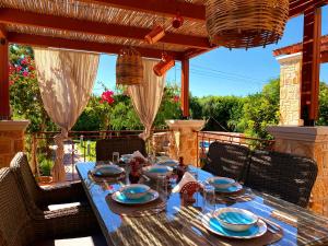 stół z niebieskimi płytami i serwetkami na patio w obiekcie Lucidum Rhodian Gastronomy Villa w mieście Faliraki