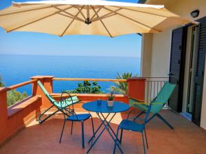 a patio with a table and chairs and an umbrella at Terramare in Castel di Tusa