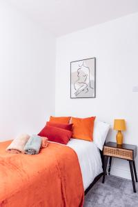 a bedroom with a bed with an orange blanket at Brown Ball in Barrow in Furness