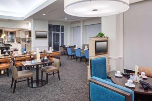 un ristorante con tavoli, sedie e televisore di Hilton Garden Inn Hilton Head a Hilton Head Island