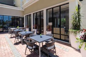 um pátio exterior com mesas, cadeiras e janelas em Hilton Garden Inn Jacksonville/Ponte Vedra em Ponte Vedra Beach