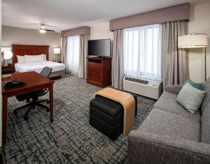 a hotel room with a bed and a couch and a desk at Homewood Suites by Hilton Jacksonville-South/St. Johns Ctr. in Jacksonville