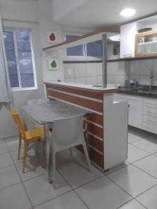 une cuisine avec une table, des chaises et un comptoir dans l'établissement Terrazzo PontaNegra flat Flat Vista Mar Apto 201, à Natal