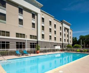 a hotel with a swimming pool in front of a building at Hampton Inn & Suites Mobile I-65@ Airport Boulevard in Mobile