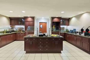 a large kitchen with wooden cabinets and counters at Homewood Suites by Hilton Tampa Airport - Westshore in Tampa