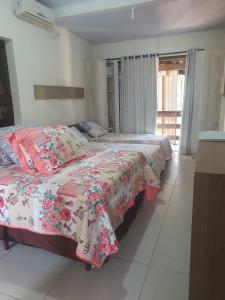 a bedroom with two beds and a window at Pousada Estrela da Manhã in Penha