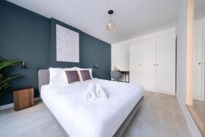 a bedroom with a large white bed with blue walls at Stella Stays Distinctive 1 BDR Etiler in Istanbul