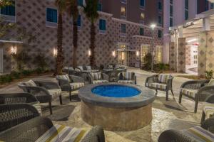 Hampton Inn & Suites Tampa Airport Avion Park Westshore في تامبا: وجود فناء في الفندق مع كراسي ونافورة