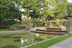 a pond in a garden with turtles in the water at Bern room near Main Station in Bern