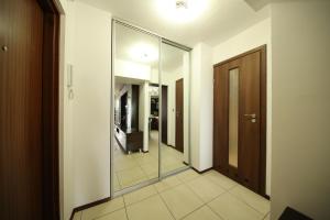un couloir avec un miroir et une porte dans l'établissement BRONCO APARTMENTS, à Varsovie