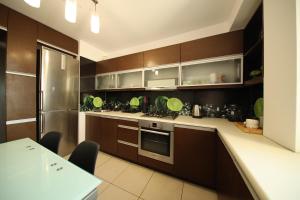 uma cozinha com armários de madeira e um frigorífico de aço inoxidável em BRONCO APARTMENTS em Varósvia