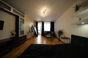 um quarto com uma cama e uma sala de estar em BRONCO APARTMENTS em Varósvia
