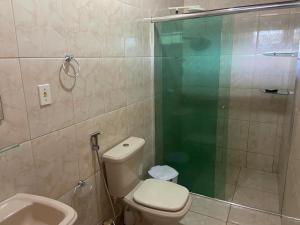 a bathroom with a shower and a toilet and a sink at Residencial das Cachoeiras in Presidente Figueiredo