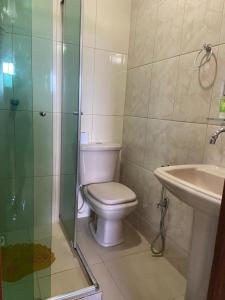 a bathroom with a toilet and a shower and a sink at Residencial das Cachoeiras in Presidente Figueiredo