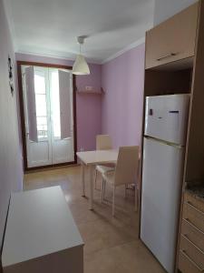 a kitchen with a white refrigerator and a table at Apartamento Paseo Fluvial in Tui