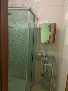 a bathroom with a glass shower and a sink at Residencial das Cachoeiras in Presidente Figueiredo
