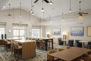 uma sala de jantar com mesas, cadeiras e janelas em Homewood Suites by Hilton Knoxville West at Turkey Creek em Knoxville