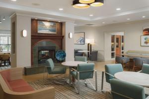 a lobby with tables and chairs and a fireplace at Homewood Suites by Hilton Knoxville West at Turkey Creek in Knoxville