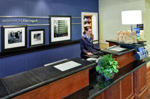 a woman sitting at a counter in a waiting room at Hampton Inn & Suites Knoxville-Turkey Creek Farragut in Knoxville