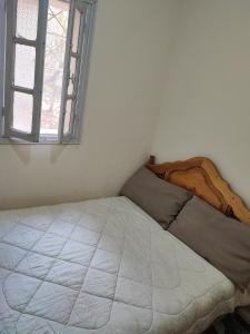 Ce lit se trouve dans un dortoir blanc doté d'une fenêtre. dans l'établissement Dardiyafa, à Azrou