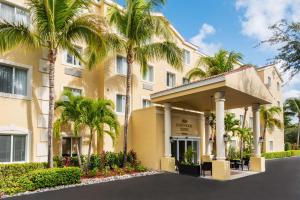 a building with palm trees in front of it at Homewood Suites by Hilton Bonita Springs in Bonita Springs