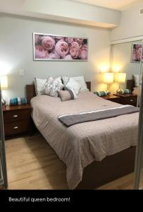 um quarto com uma cama com rosas cor-de-rosa na parede em Beautiful Unit in Heart of Downtown Toronto em Toronto