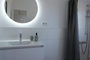 a bathroom with a sink and a mirror at Inselbutze Borkum in Borkum