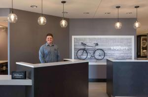 a woman standing at a counter with a bike on the wall at Hampton Inn & Suites Tallahassee Capitol-University in Tallahassee