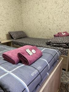 two beds in a room with pink towels on them at Asia Minor in Samarkand