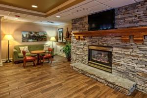 a living room with a stone fireplace with a flat screen tv at Hampton Inn Concord/Kannapolis in Kannapolis