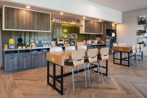 a kitchen with wooden cabinets and bar stools at Home2 Suites By Hilton Tampa Downtown Channel District in Tampa