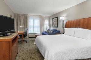 a hotel room with a large bed and a television at Hilton Garden Inn Tampa Airport/Westshore in Tampa