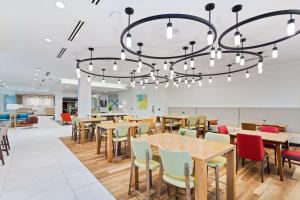 une salle à manger avec des tables et des chaises ainsi qu'un lustre dans l'établissement Hilton Garden Inn Homestead, Fl, à Homestead