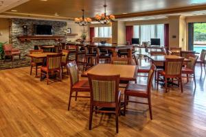 a restaurant with tables and chairs and a fireplace at Hampton Inn Charlotte/Matthews in Charlotte