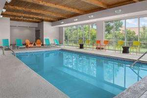 een zwembad met kleurrijke stoelen en tafels bij Home2 Suites By Hilton Summerville in Summerville