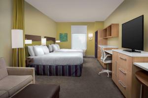 a hotel room with a bed and a flat screen tv at Home2 Suites By Hilton Summerville in Summerville