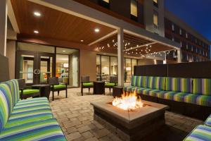 een patio met 2 stoelen en een vuurplaats bij Home2 Suites by Hilton Champaign/Urbana in Champaign
