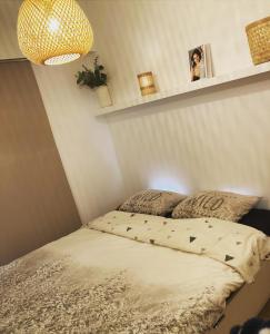 Bett in einem kleinen Zimmer mit einer Lampe und einem Bettgitter in der Unterkunft Carpe Diem in De Haan